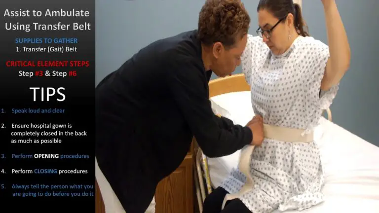 A person helps another tie a transfer belt in a medical setting. Instructions for using the belt and related tips are displayed on the side.